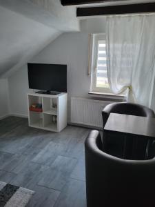 赫费尔霍夫Ferienwohnung的客厅配有平面电视和椅子