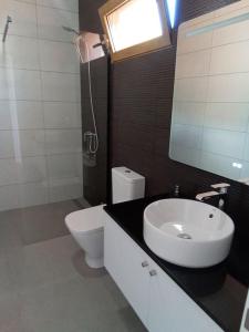 圣港Praia Encantada的浴室配有白色卫生间和盥洗盆。