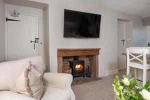 彭里斯Brunswick Cottage的客厅设有壁炉和电视。