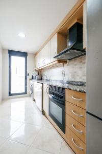 卡耐特蒂贝兰格Lujoso apartamento de dos habitaciones en la playa de Canet的一间设有白色家电和窗户的大厨房