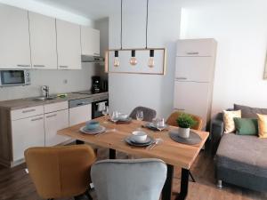 施图拜河谷新施蒂夫特Appartements Kleeblatt的一间带木桌和椅子的厨房以及一间用餐室