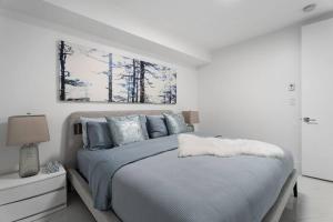 温哥华Brand New 2 Bedroom Point Grey Getaway的白色卧室配有一张带蓝色枕头的大床