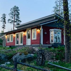 HuutotöyryVuolenkosken Helmi - laadukas ympärivuotinen kohde的前面有一棵树的红色小房子