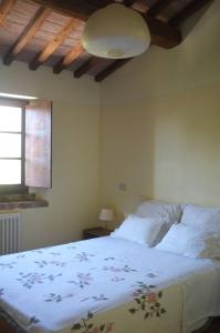GrottiCountry house at Podere Noceto的卧室配有一张带白色棉被的大床