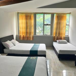 麦德林Hotel Casa Botero Medellín RNT 152104的一间卧室设有两张床和两个窗户。