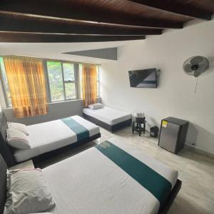麦德林Hotel Casa Botero Medellín RNT 152104的一间带两张床的卧室和一台电视