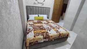 非斯Ibraimo的一张带毯子和黄色枕头的床