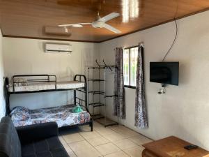 曼努埃尔安东尼奥Pura Natura Lodge Manuel Antonio的客房设有两张双层床和一台平面电视。