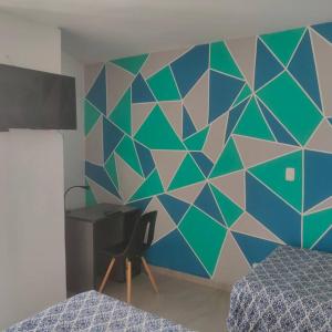 基多Perfect Suite, near everything! ¡cerca de todo!的一间卧室设有蓝色和绿色的墙壁,配有书桌