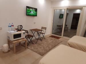 开罗Fantastic new rooms close to New Cairo Festival City and airport的客厅配有微波炉和桌椅