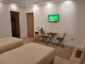 开罗Fantastic new rooms close to New Cairo Festival City and airport的客房设有两张床、一张桌子和电视。