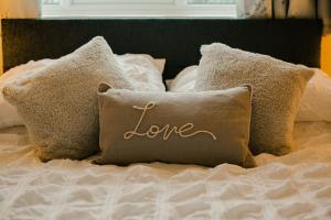 里辛Granary at Tyddyn Isaf的床上写着爱字的枕头