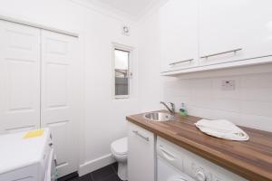 伦敦伦敦之家度假屋的白色的浴室设有水槽和卫生间。
