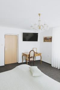 兰什克龙Penzion Jakub的一间卧室配有一张床、一张桌子和一个吊灯。