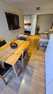 圣卡洛斯-德巴里洛切Apartamento Urquiza的一间带木桌的客厅和一间卧室