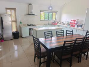 南迪Large 4 bedroom villa with Pool in Sonaisali Nadi的厨房配有桌椅和冰箱。