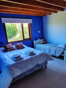 埃尔卡拉法特My home 2的一间蓝色卧室,配有两张床和窗户