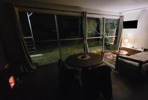 塞拉纳镇Casa Florida的客房设有桌子和大窗户。