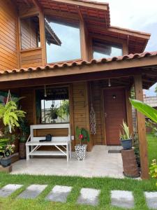 ItapemirimMillicent Residence - Chalet Milly e Chalet Iris - Itaoca Praia - ES的木屋,在庭院设有长凳