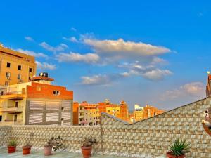 Maḩallat al BurjLuxury 5 star apartment with rooftop, security的建筑前方砖墙,有盆栽植物