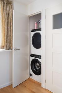 鹿特丹Apartment Heart of Rotterdam的洗衣房配有2台洗衣机和烘干机