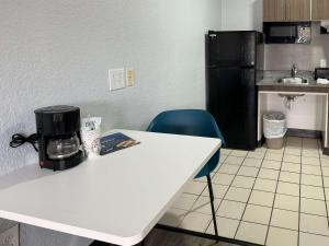 西棕榈滩西棕榈滩6号一室公寓酒店的厨房配有白色桌子和黑色冰箱。