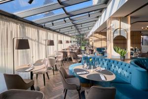 普罗夫迪夫Hotel Imperial Plovdiv, a member of Radisson Individuals的餐厅设有蓝色的沙发和桌椅
