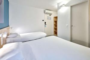 纳博讷Kyriad Direct Narbonne Sud的客房设有两张床和一个衣柜。