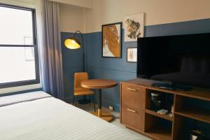 旧金山Hotel Julian的一间卧室配有一张床和一张书桌及电视