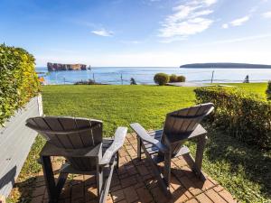 佩尔塞勒米拉奇酒店 的两把椅子坐在一个眺望着大海的庭院上