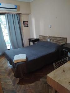 布宜诺斯艾利斯Hotel Manzanares Plaza的一间卧室配有一张床、一张书桌和一个窗户。