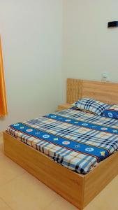 科托努Timba chiclieu的卧室内的一张床铺,配有木制床架