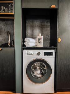 堪培拉The Green Rooms - Luxury themed micro apartments inspired by tiny home design的小厨房内的洗衣机和烘干机