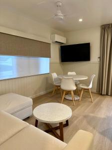 Tinaroo蒂纳鲁湖度假酒店的客厅配有沙发、桌子和平面电视。