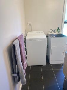 皮克顿Peaceful Picton Home的一间带洗衣机和水槽的浴室