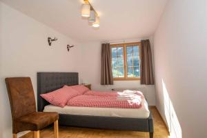 阿德尔博登Am Strubelweg的一间卧室配有一张带红色枕头的床和一扇窗户