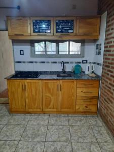 罗克萨恩斯培尼亚总统城Lo de Milo的一个带木制橱柜和水槽的厨房