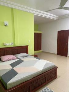 Abomey-CalaviTimba chic-villa的一间卧室设有一张带绿色墙壁的大床