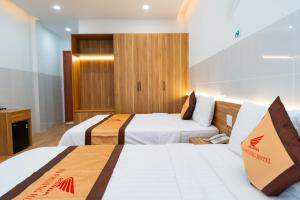 Tánh LinhKHÁCH SẠN HÀ PHƯƠNG的一间酒店客房,设有两张床和电视
