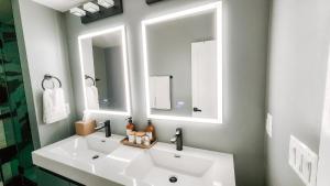 华盛顿Private Modern Luxury Suite in Historic Stone Home的浴室设有白色水槽和两面镜子
