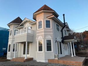 御代田町Queen Anne Style Luxury Vacation Villa的带阳台的大型白色房屋