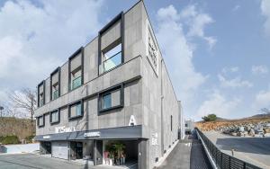 杨平郡No25 Hotel Yangpyeong Seojong的一座灰色的建筑,旁边有一个标志