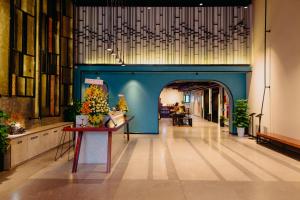 芽庄Em Oi Boutique Hotel的走廊上设有蓝色的墙壁和鲜花桌