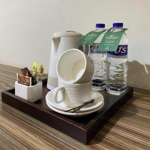 马卡萨菲尼西旅行者酒店的一个带咖啡壶和两瓶水的托盘