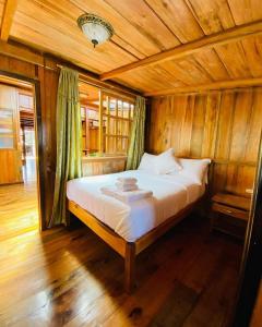 明多Guayabo Hostal Spa的木制客房内的一间卧室,配有一张床