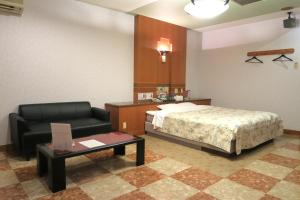 鸟栖市Hotel Silk no Mori (Adult Only)的一间卧室配有一张床、一把椅子和一张桌子