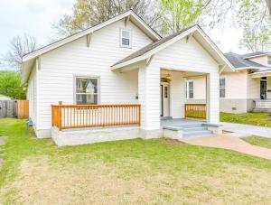 孟菲斯Chic Crosstown Bungalow with large fenced backyard的白色的房子,设有木栅栏