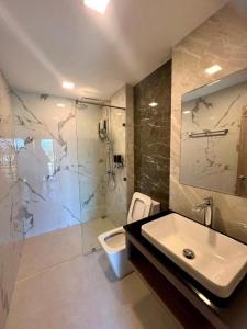 武里南JIA HAUS Hotel Apartment的浴室配有卫生间、盥洗盆和淋浴。