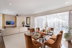 塞米亚克The Luxury Collection, Monaco Blu的用餐室以及带玻璃桌和椅子的客厅