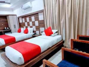 达兰萨拉Hotel King Castle Central Heated & Air cooled的两张位于酒店客房的床,配有红色和白色枕头